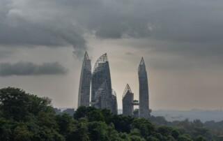Reflections at Keppel Bay residential towers behind tropical greenery